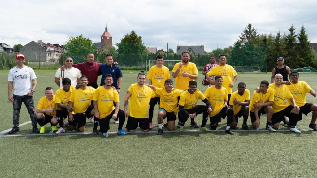 Grupa mężczyzn grających w piłkę nożną na boisku