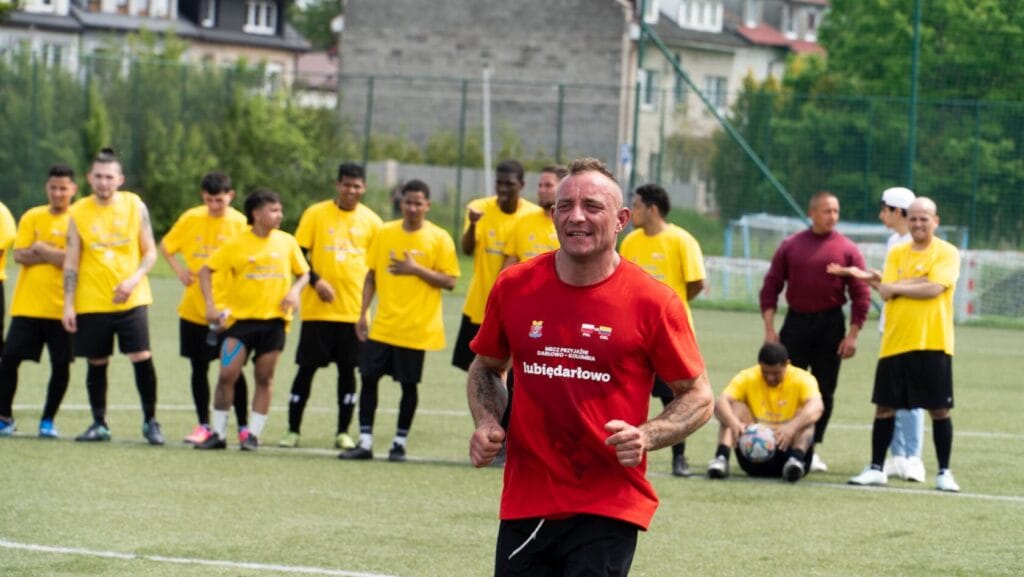 Trener bie na boisku piłkarskim podczas zajęć