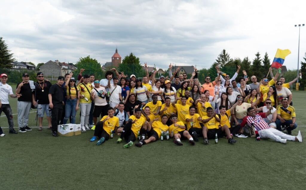 Zespół osób świętujących na boisku piłkarskim