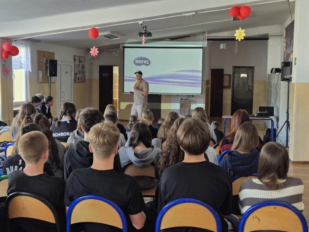 Prelegent na szkolnej auli przed grupą uczniów