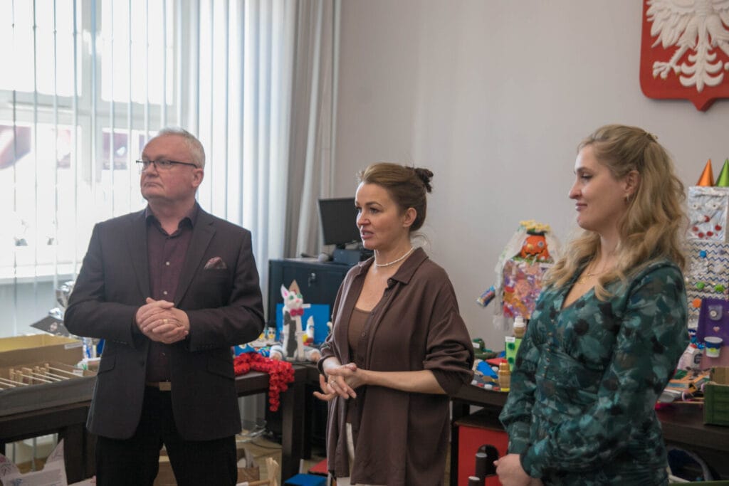 Trzy osoby w biurowym pomieszczeniu z dekoracjami