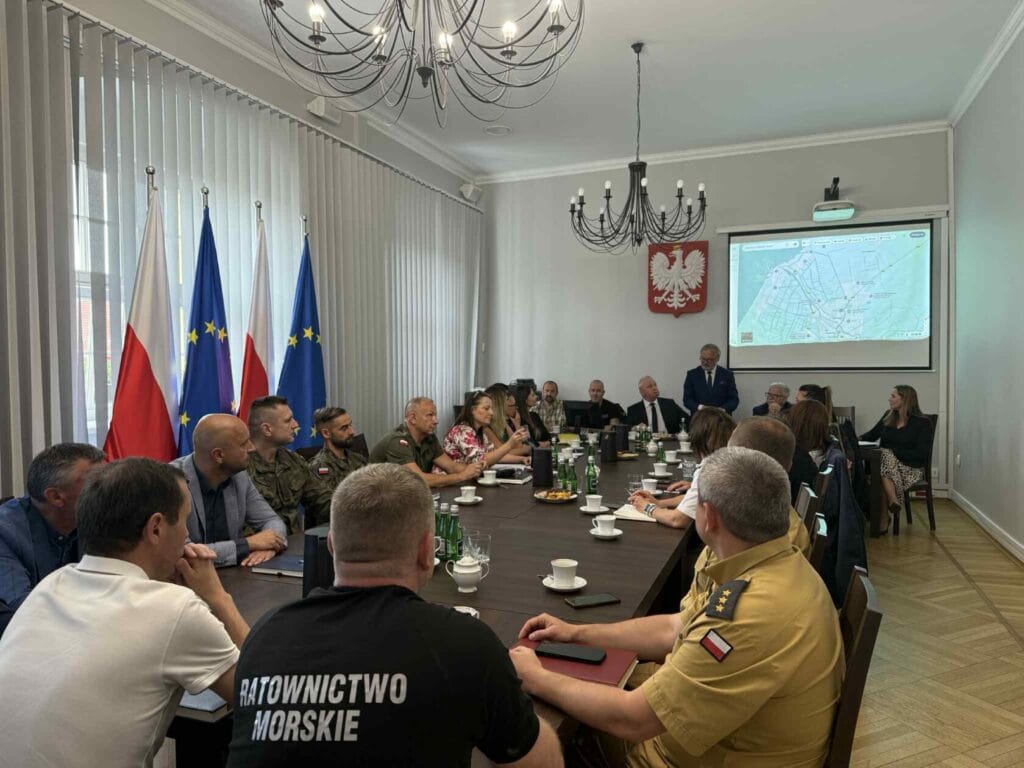 Spotkanie oficjeli i mundurowych przy stole z mapą