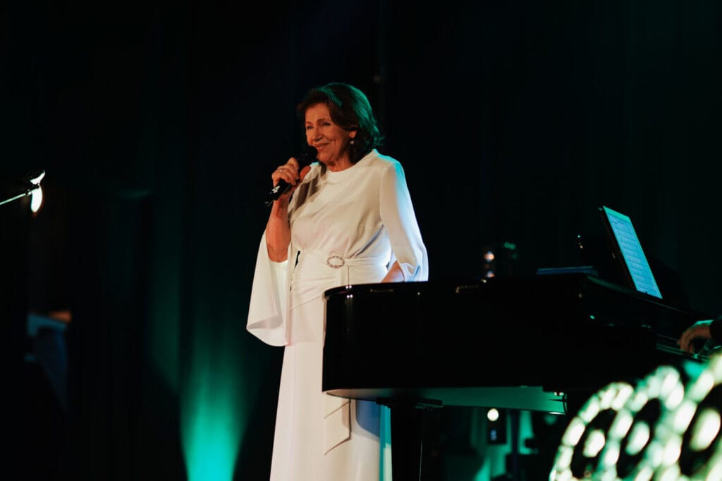 Kobieta śpiewa przy fortepianie na scenie
