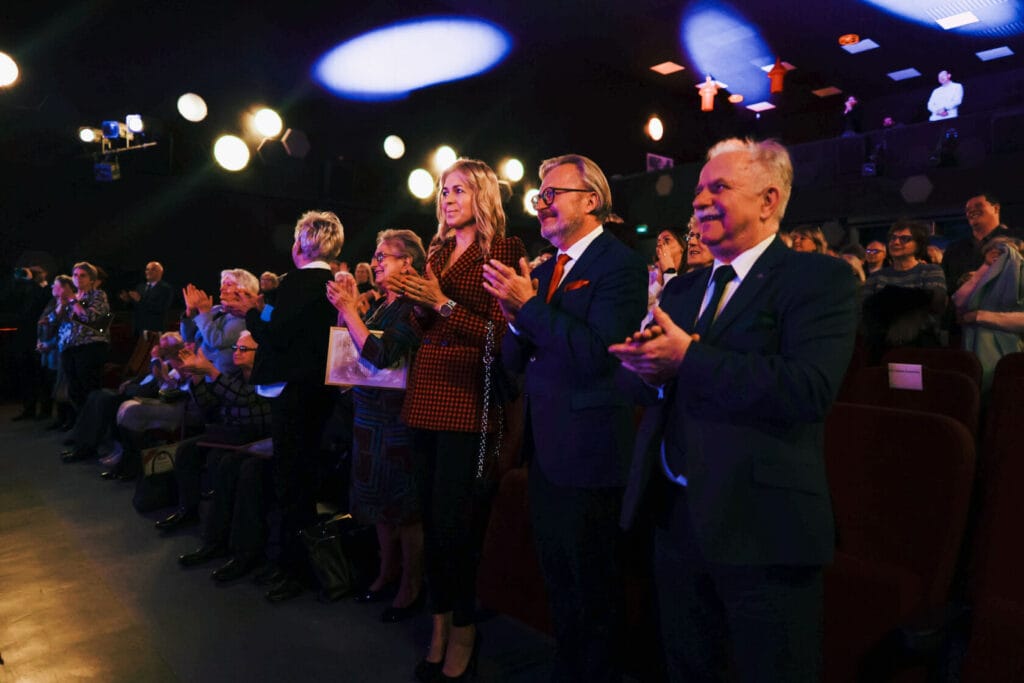 Grupa osób oklaskuje na wydarzeniu kulturalnym