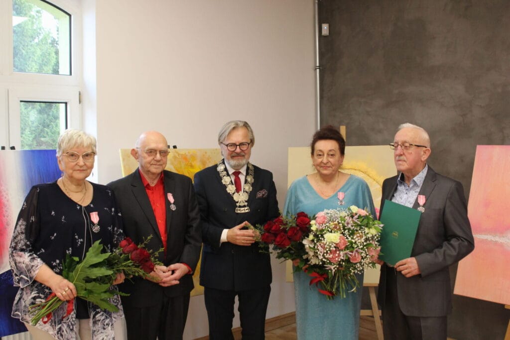 Starsi ludzie z odznaczeniami i kwiatami na uroczystości
