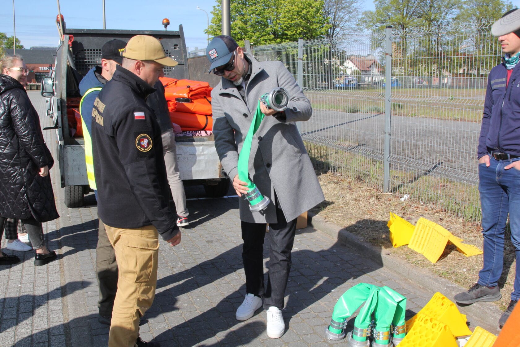 IMG_0184 Strażak i mężczyźni pracujący przy rozwijaniu zielonego węża