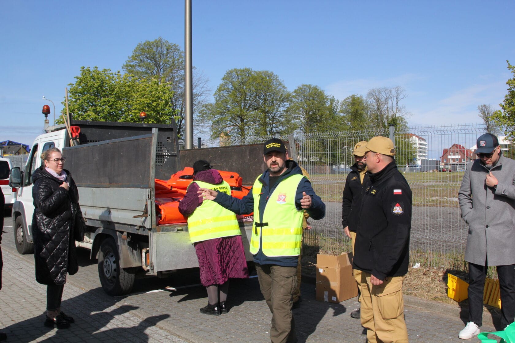 IMG_0187 Ludzie w kamizelkach odblaskowych przy samochodzie, rozdają kamizelki.