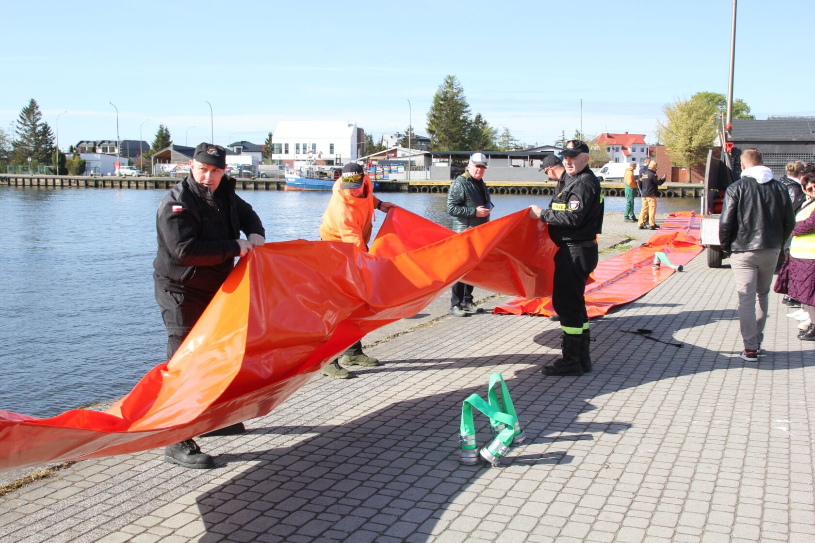 IMG_0222 Ratownicy rozkładają dużą pomarańczową plachtę nad wodą