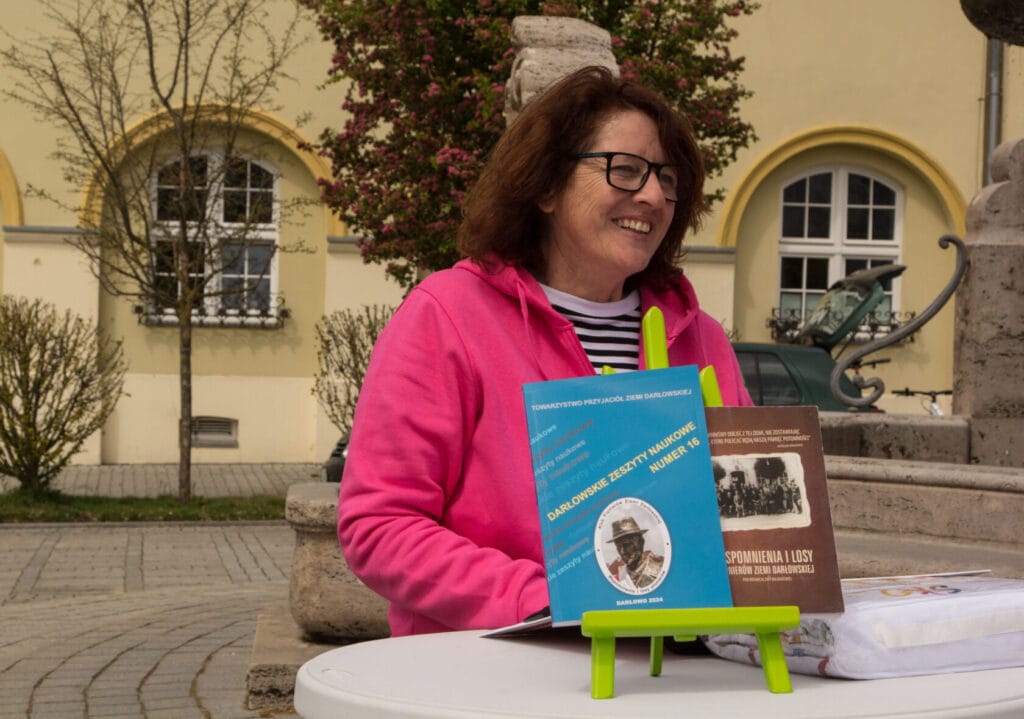 Kobieta z książkami promującymi historię, przy stoliku