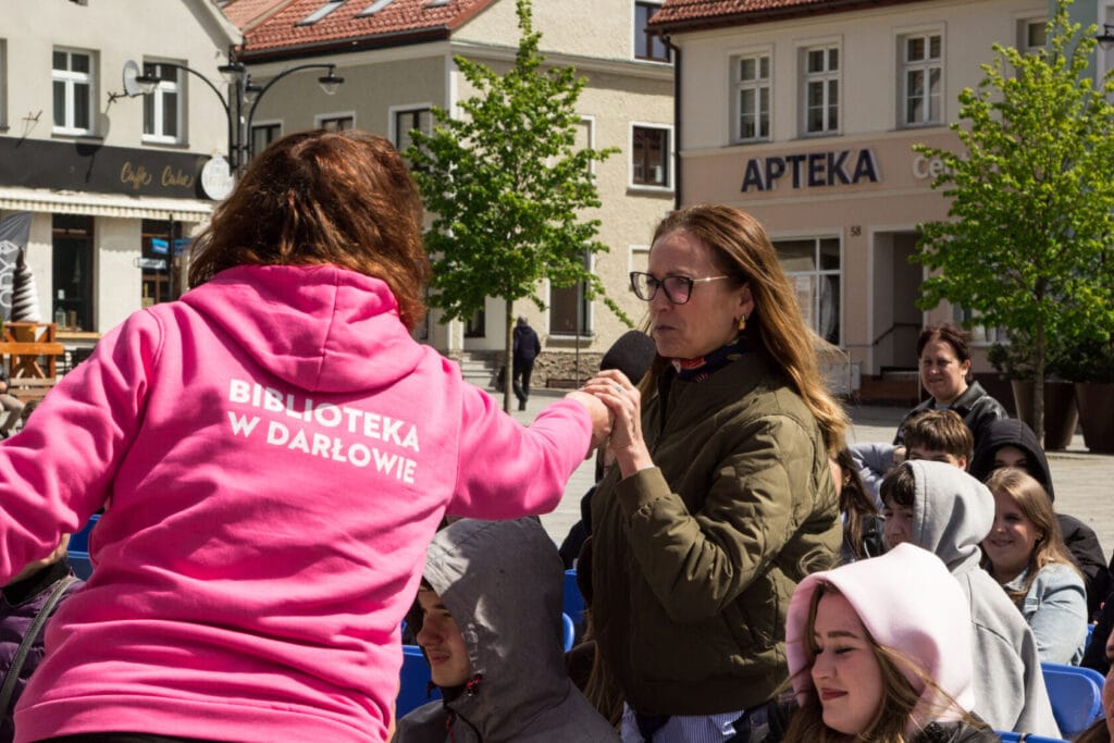 Kobieta z mikrofonem przeprowadza wywiad na zewnątrz