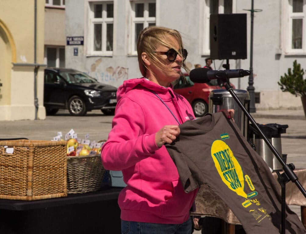 Kobieta pokazuje koszulkę na miejskim wydarzeniu
