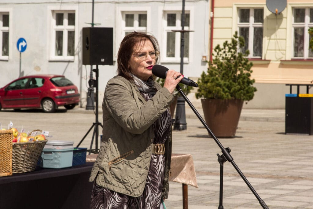 Kobieta przemawia przez mikrofon na zewnątrz