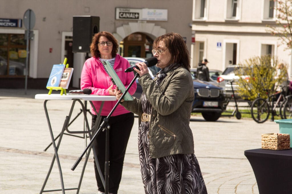 Kobieta przemawiająca przez mikrofon na miejskim wydarzeniu