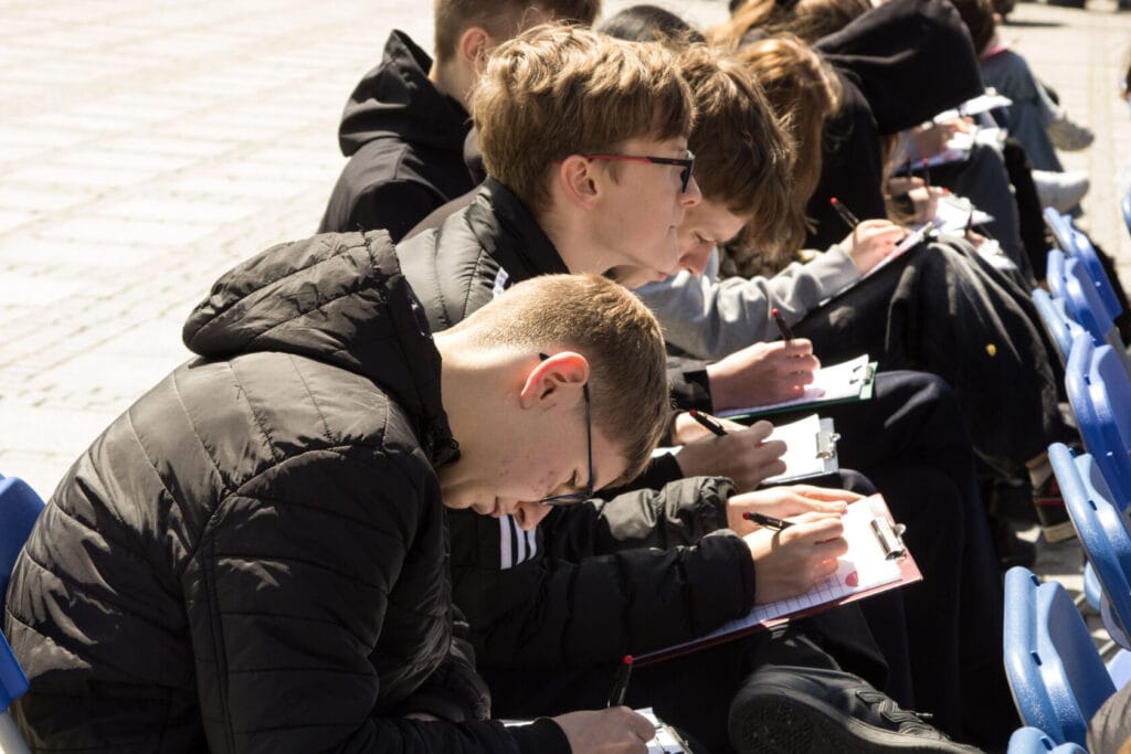 Studenci rysujący na zewnątrz na trybunach
