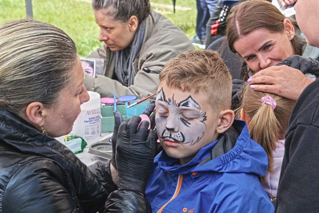 Chłopiec malowany na twarz kotem na festynie