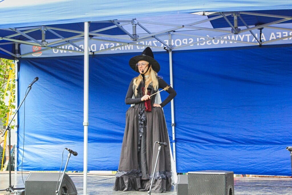 Kobieta w stroju czarownicy śpiewa na scenie