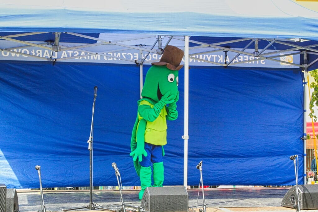 Maskotka w zielonym kostiumie na scenie