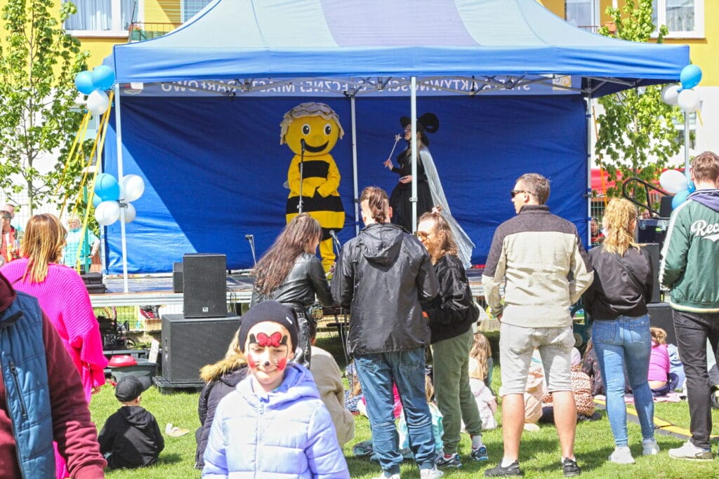 Rodzinne wydarzenie na zewnątrz z maskotką i publicznością