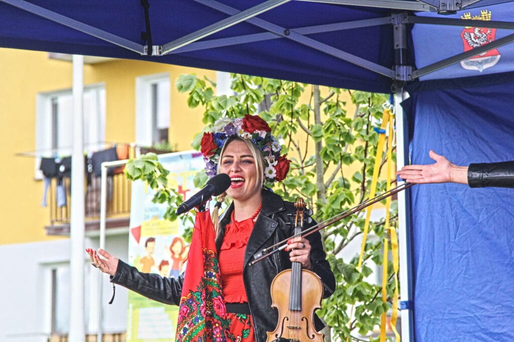 Śpiewaczka w tradycyjnym stroju z skrzypcami na scenie