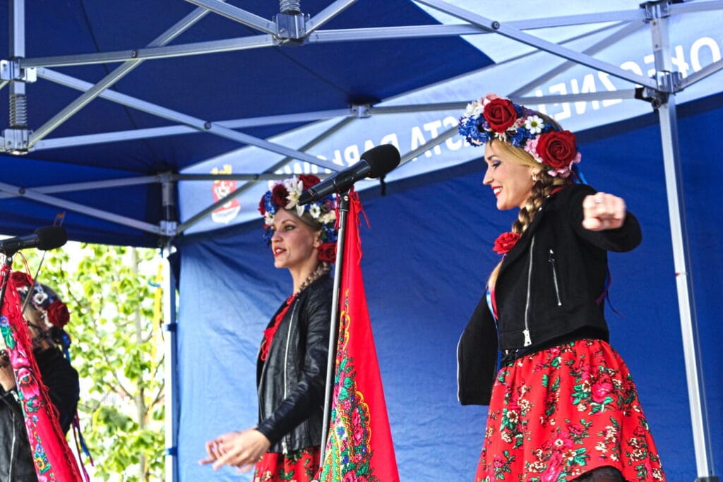 Tancerki w tradycyjnych strojach wykonują ludowy taniec.