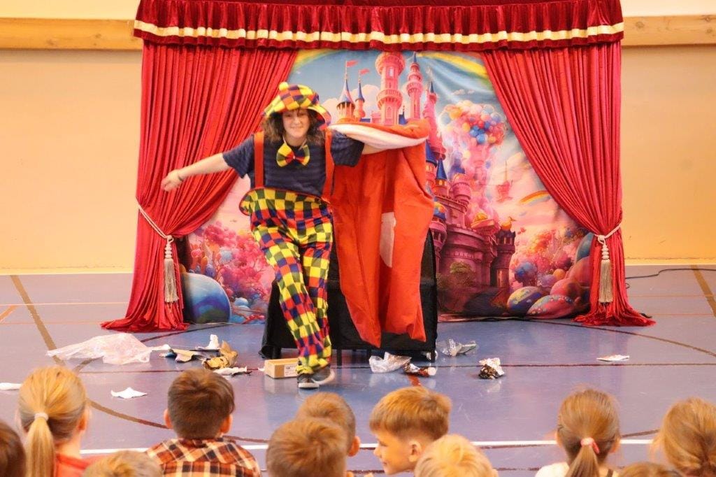 Klaun występuje przed dziećmi w szkole.