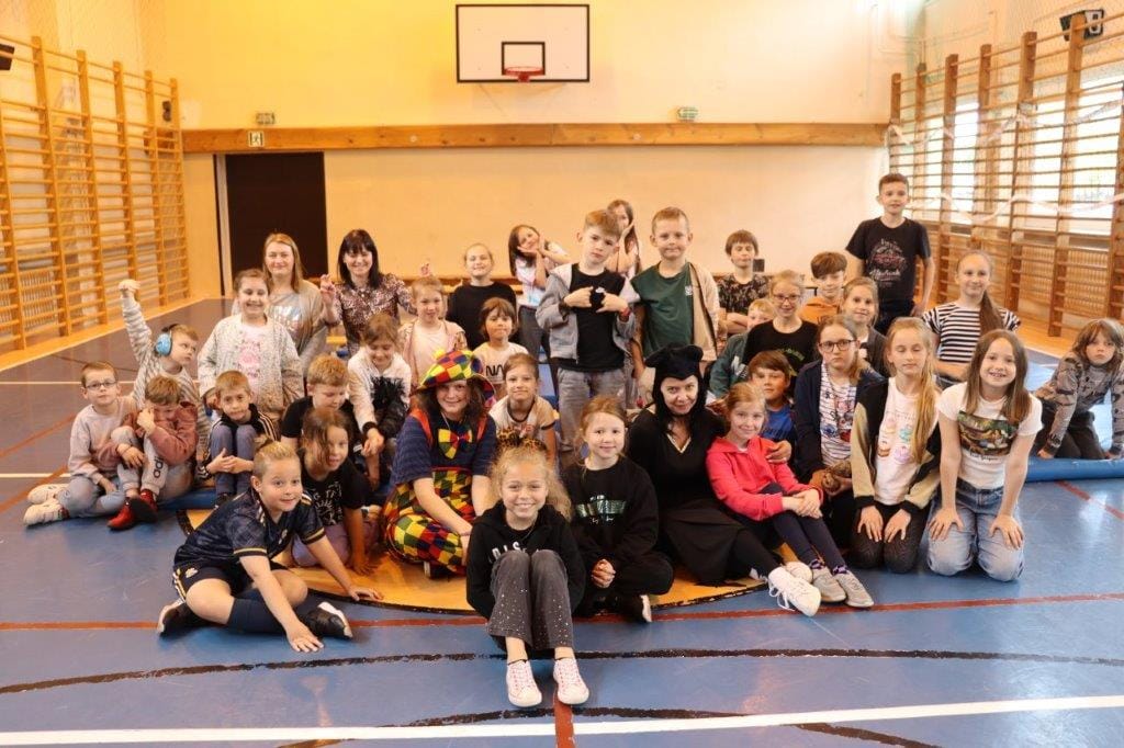 Grupa dzieci z nauczycielami na sali gimnastycznej