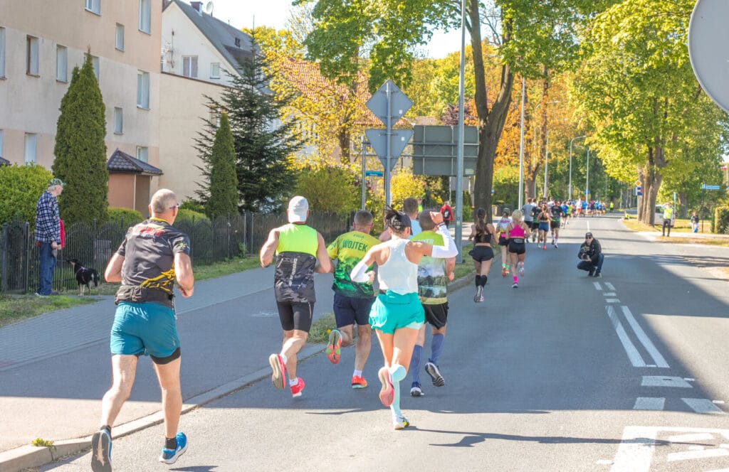 Biegacze uczestniczący w miejskim maratonie na ulicy