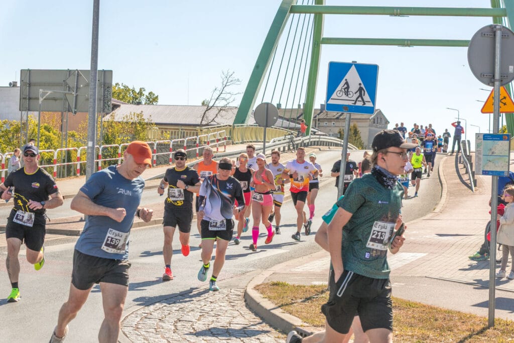 Biegacze uczestniczą w maratonie na miejskim moście