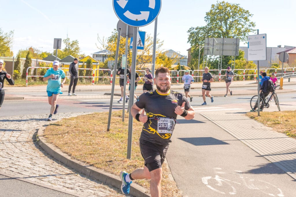 Uśmiechnięty biegacz podczas maratonu w słoneczny dzień