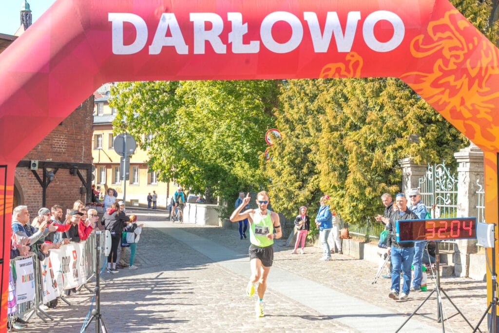 Biegacz przekracza metę maratonu w Darłowie