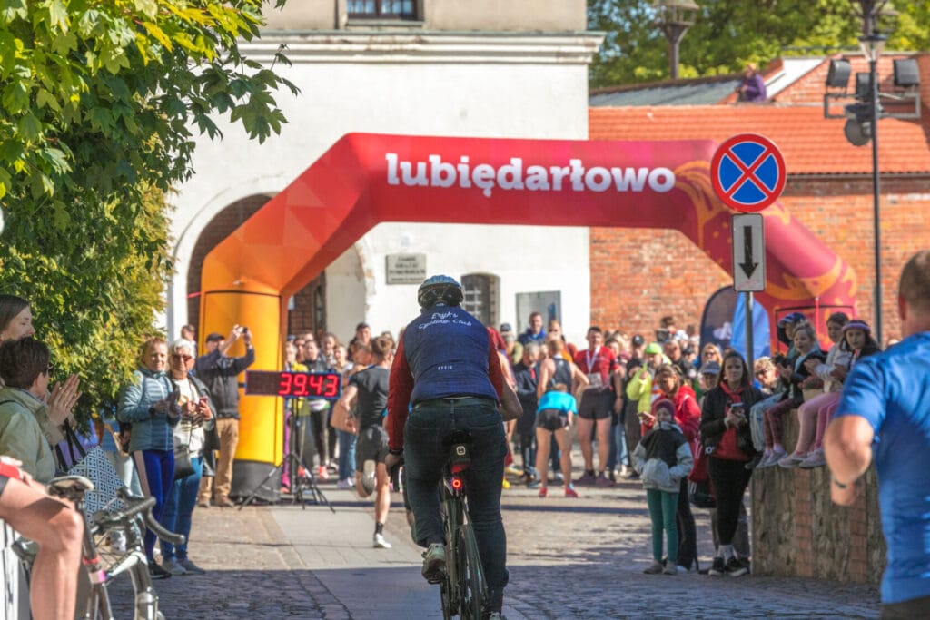 Rowerzysta przekracza linię mety, tłum kibiców