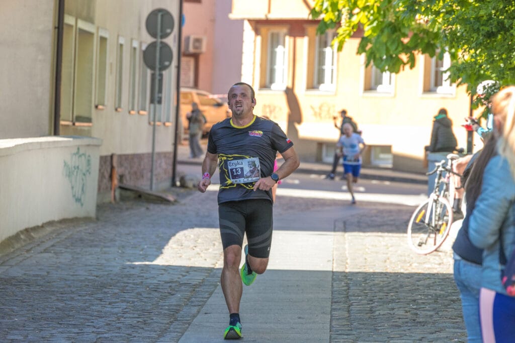Biegacz podczas maratonu na brukowanej ulicy