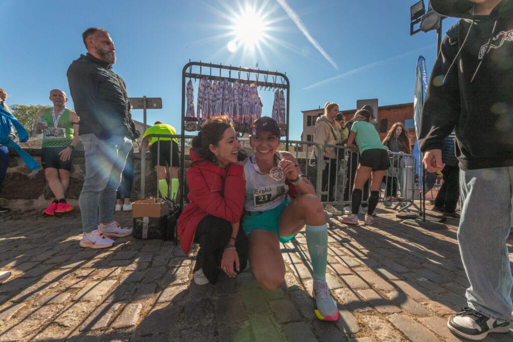 Biegaczki świętują ukończenie maratonu, słońce w tle