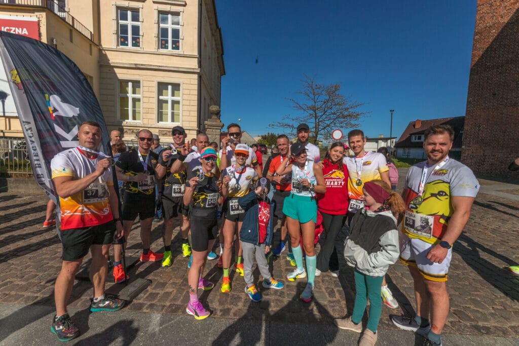 Grupa biegaczy z medalami na ulicy po maratonie