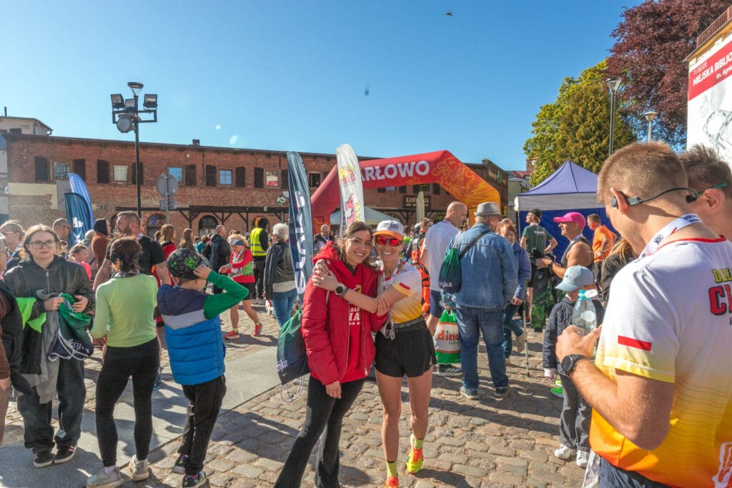 Uczestnicy po maratonie śmieją się i rozmawiają na zewnątrz