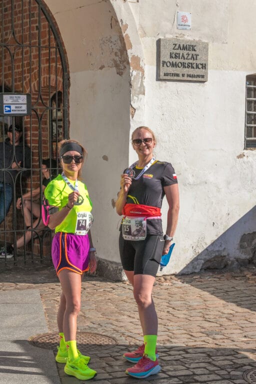 Kobiety biegacze z medalami przed Zamkiem Książąt Pomorskich