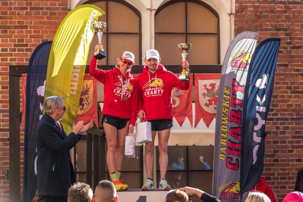 Zwycięzcy wyścigu charytatywnego z trofeami na podium