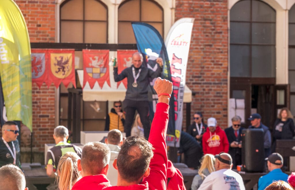 Zwycięzca na podium, publiczność klaszcze na wydarzeniu sportowym