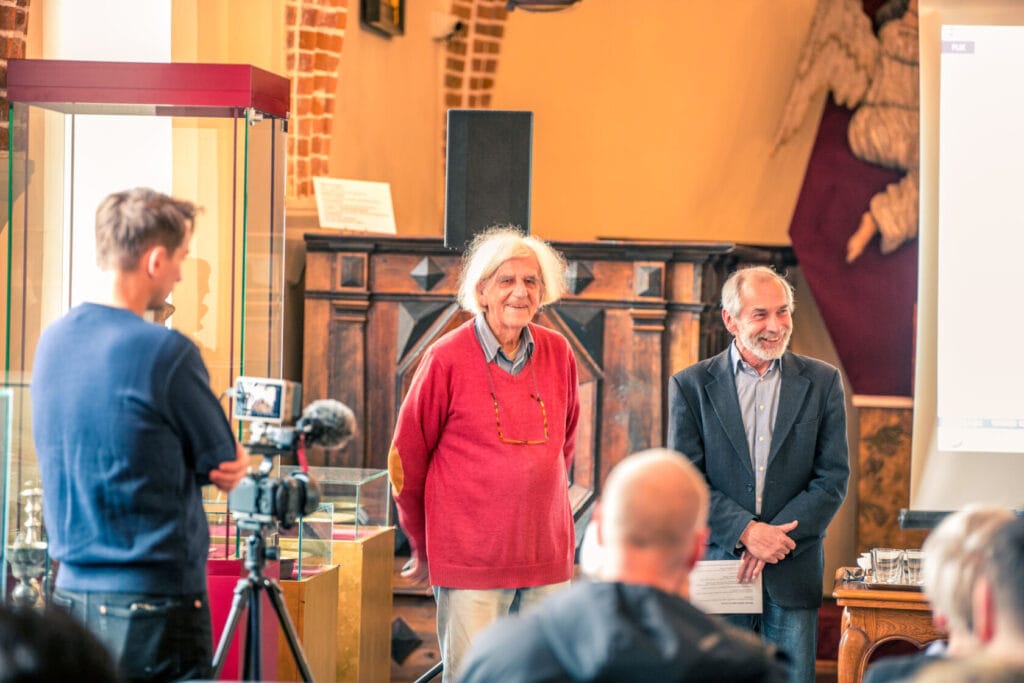 Starszy mężczyzna przemawia na konferencji