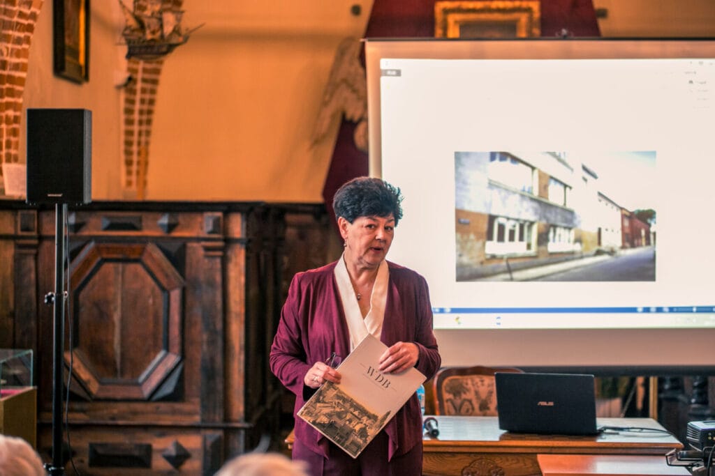 Kobieta prezentuje historyczne zdjęcia na konferencji