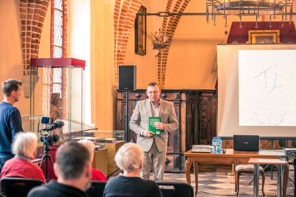 Mężczyzna prezentuje książkę podczas wykładu w kościele