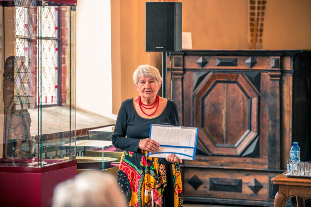 Starsza kobieta czyta publicznie w bibliotece