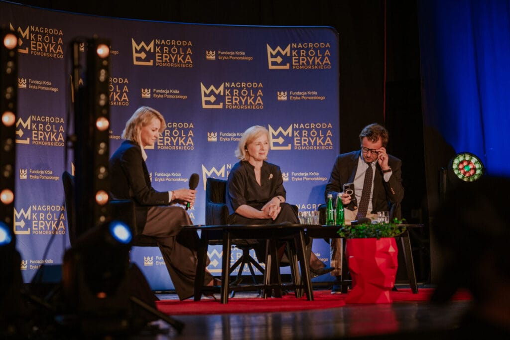 Paneliści dyskutują na scenie z nagrodą Króla Eryka