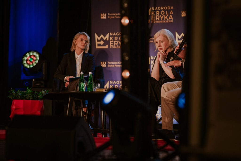 Dwie kobiety dyskutujące na scenie podczas konferencji