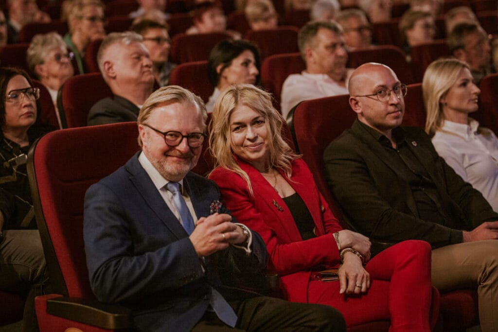 Pary na wykładzie w teatrze, mężczyzna w niebieskim garniturze