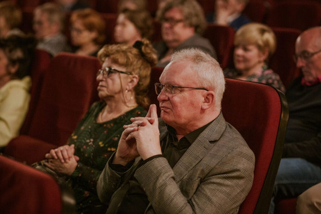 Starszy mężczyzna zamyślony na widowni teatru