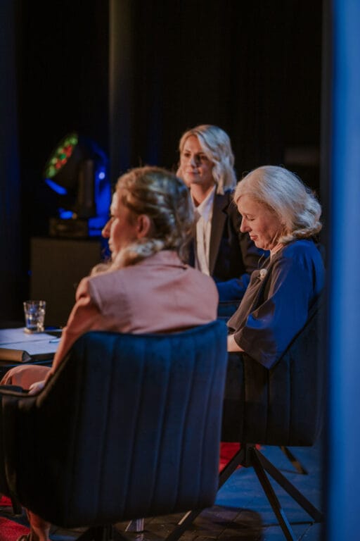 Trzy kobiety uczestniczą w dyskusji na scenie