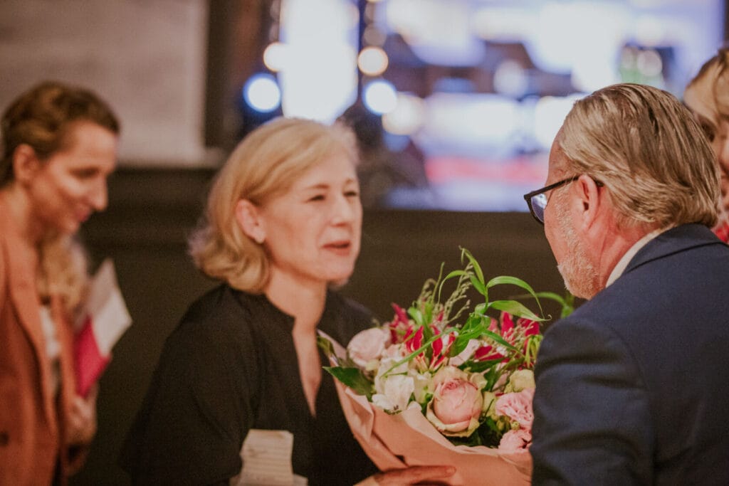 Kobieta otrzymuje bukiet kwiatów od mężczyzny w restauracji