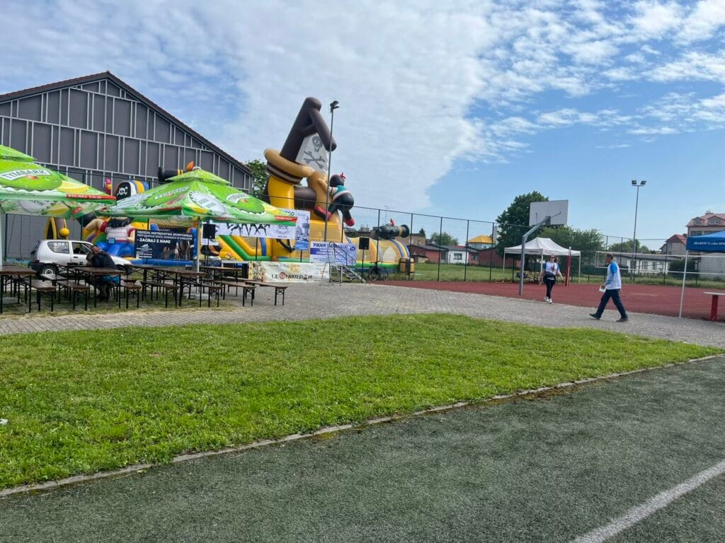 Boisko z dmuchańcami i ludźmi na festynie