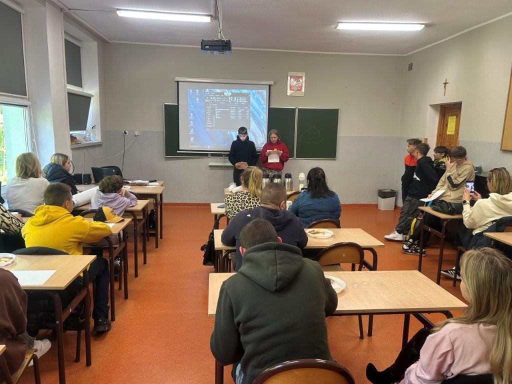 Uczniowie słuchają prezentacji w klasie szkolnej